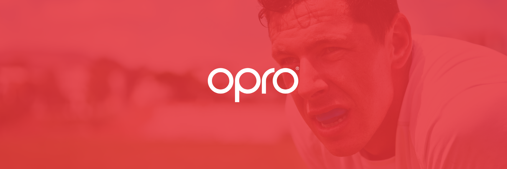 Opro logo on red backdrop of man wearing a mouthguard